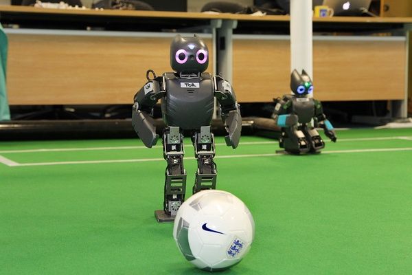 Small humanoid robots kicking a soccer ball
